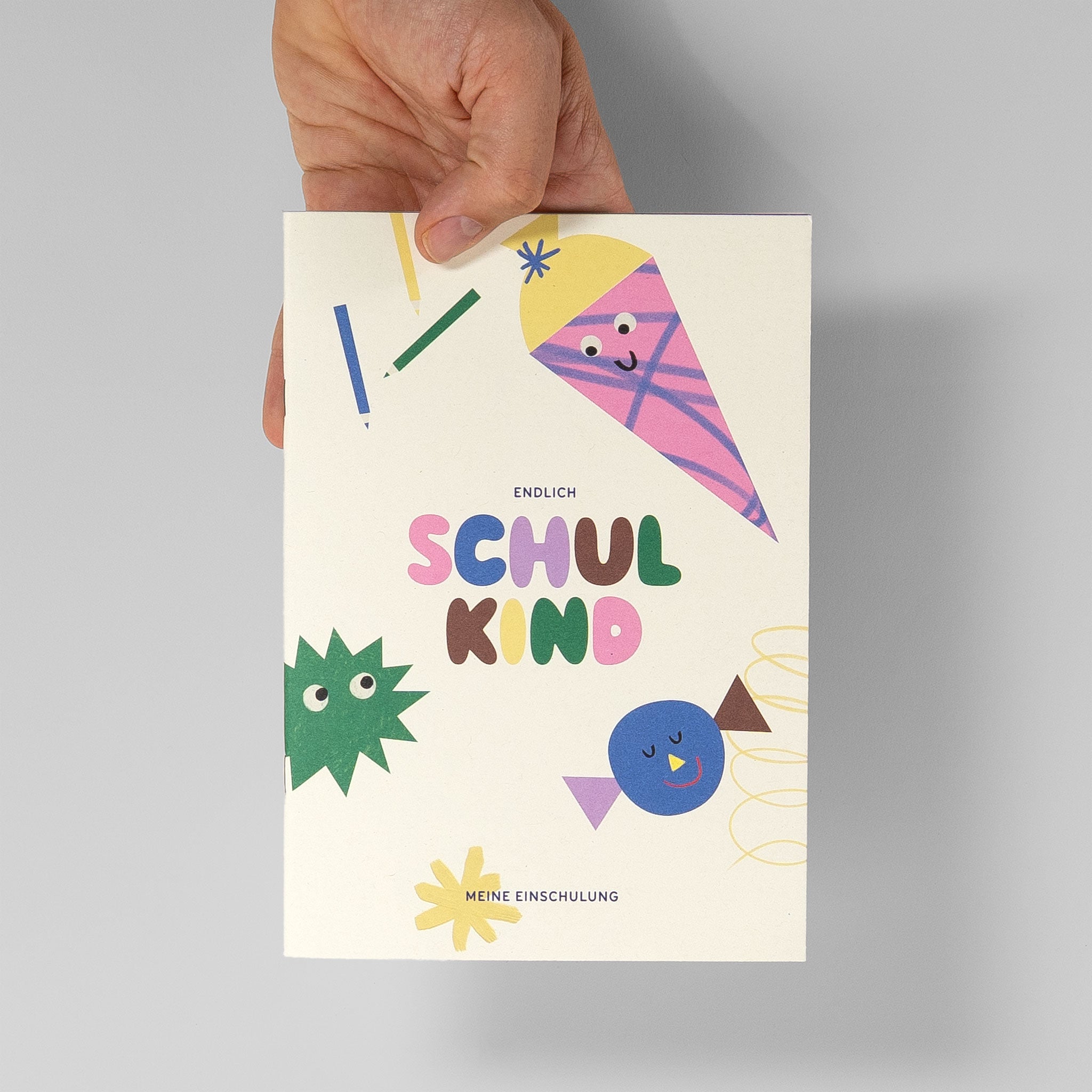 Hand hält das Minialbum – zeigt das kompakte Format zum Verschenken in der Schultüte