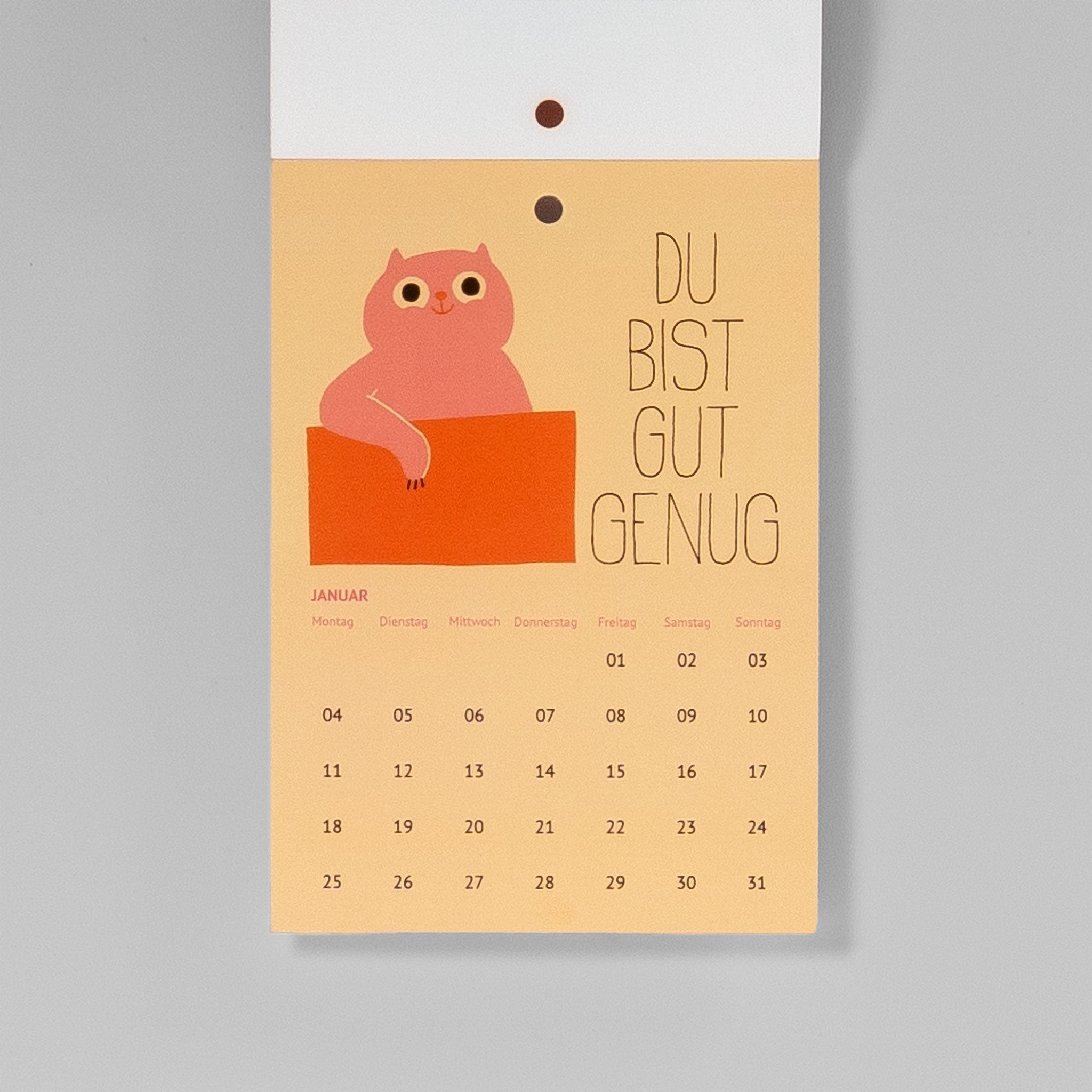 Januarblatt Du bist gut genug – rosa Katze lehnt auf einem orangefarbenen Kasten