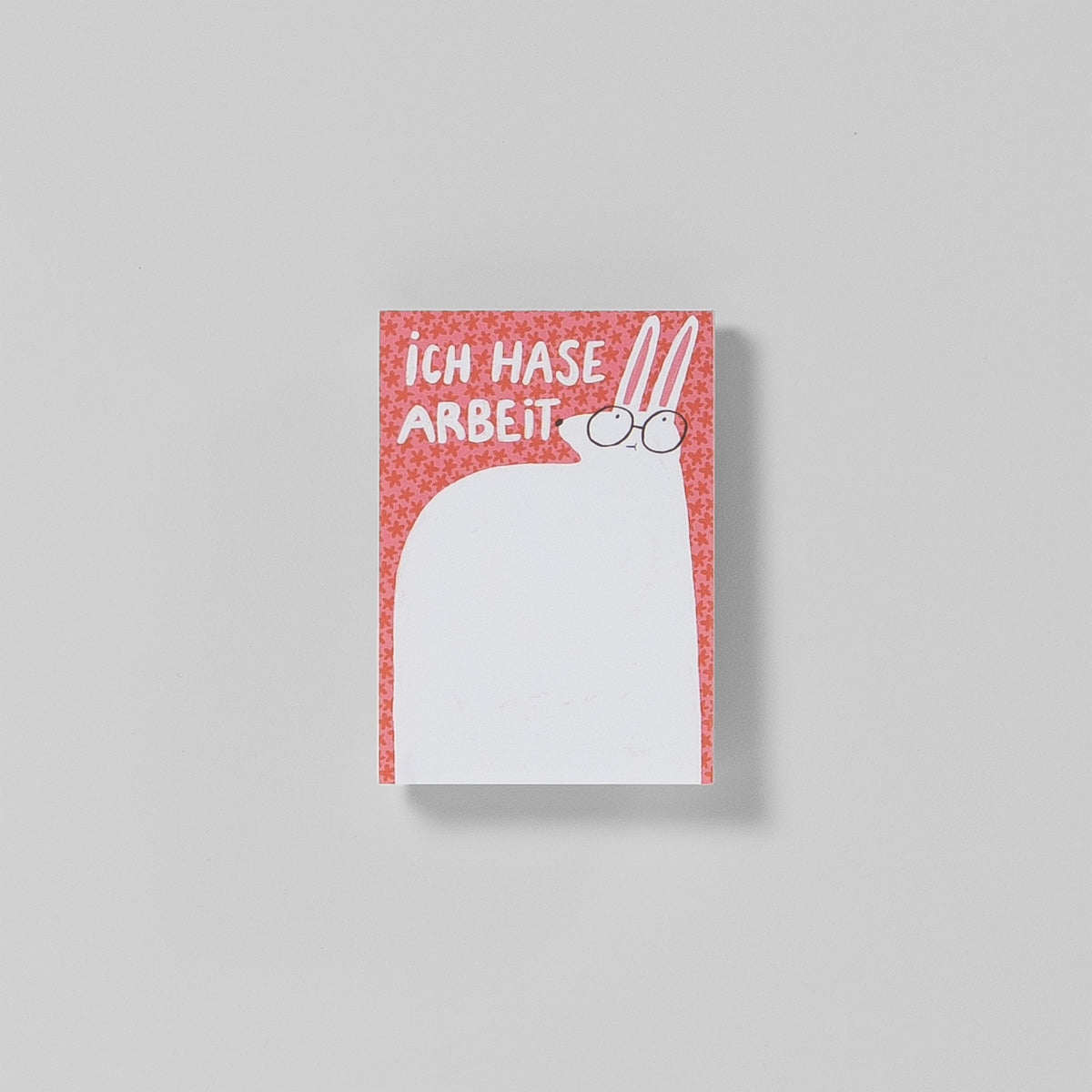 Notizblock A7 „Ich Hase Arbeit“ von Illustratorin Slinga – korallenfarbener Hintergrund mit Blümchenmuster, weißer Hase mit Brille